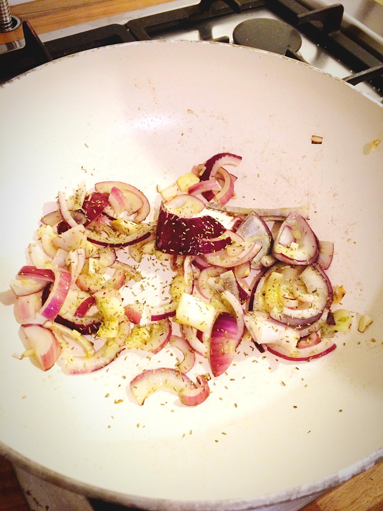large close-up of caramelizing onions in a copper pan