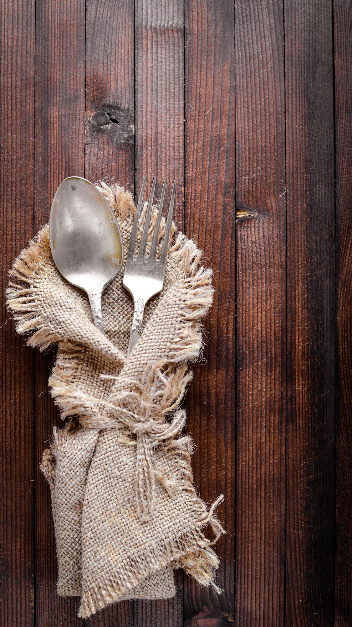 stack of folded linen napkins and wooden spoons