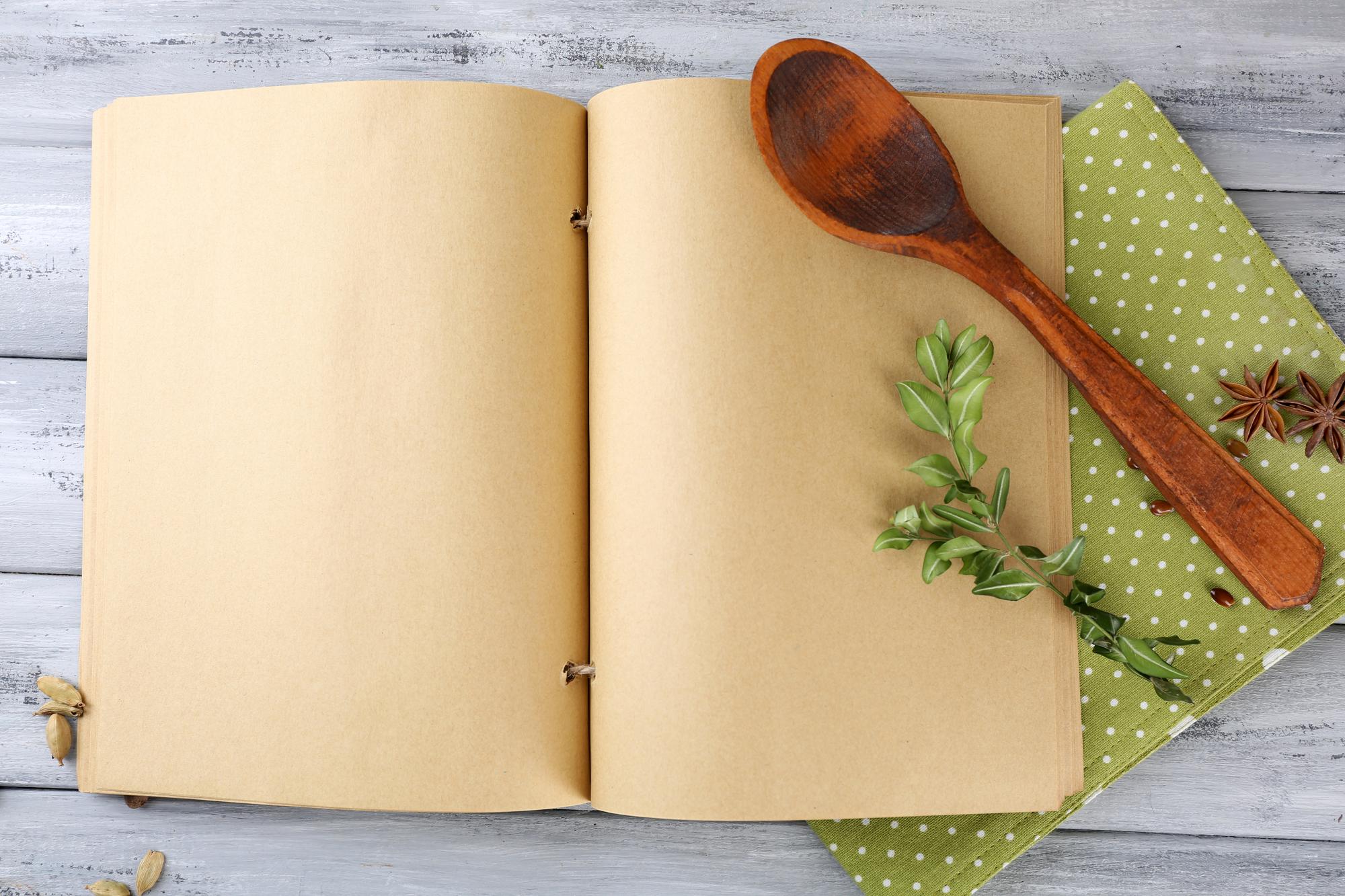 open recipe booklet and measuring spoons on paper